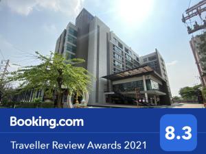 a tall building with a tree in front of it at Teddy@Thammasart in Pathum Thani