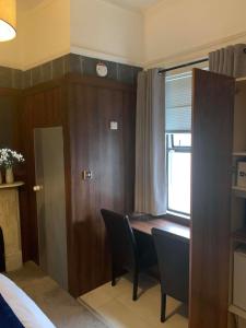 都柏林的住宿－Upstairs Studio - Private kitchenette and Small en-suite，客房设有桌椅和窗户。