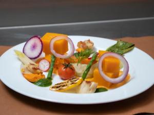 un plato de comida con verduras en una mesa en Auberge du Bachelard, en Uvernet