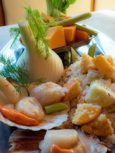 um prato de comida com camarão e legumes numa mesa em Auberge du Bachelard em Uvernet