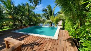 a swimming pool with a wooden deck and palm trees at Turquoise Views at Coral Views Village in French Harbour