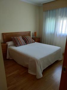 1 dormitorio con 1 cama blanca grande y ventana en Apartamento Con Piscina en Fonte de Ons4, en A Revolta
