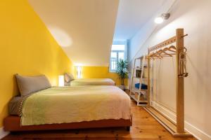 a bedroom with a bed and a yellow wall at Contador Mor Rooms and Apartments in Lisbon