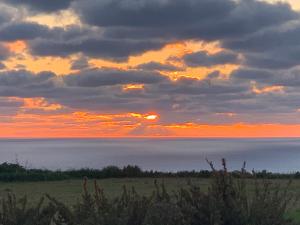 a sunset over the ocean with the sky and clouds at Fiftyfour West Boutique Living in Għarb