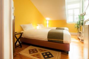 a bedroom with a bed with yellow walls and a window at Contador Mor Rooms and Apartments in Lisbon