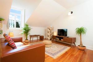 a living room with a couch and a tv at Contador Mor Rooms and Apartments in Lisbon