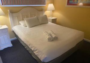 a bedroom with a bed with two slippers on it at Ocean Club Resort Myrtle Beach a Ramada by Wyndham in Myrtle Beach