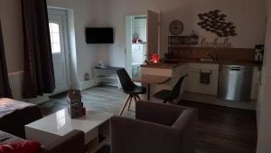 a living room with a couch and a table and a kitchen at Landidylle in Bremke