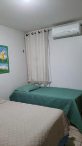 a small bedroom with two beds and a window at Aquaville - Porto das Dunas in Aquiraz