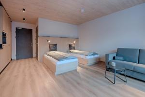 salon z dwoma łóżkami i kanapą w obiekcie Simple Life Apartments w mieście Rauris