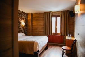 a hotel room with a bed and a window at Cal Ruiz in Pas de la Casa