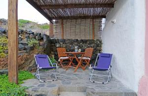 a patio with a table and two chairs and a stone wall at Terra e mare in Pantelleria