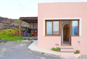 a pink house with a glass door and stairs at Terra e mare in Pantelleria +13 photos