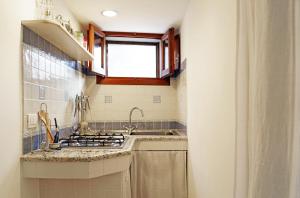 a kitchen with a stove and a sink and a window at Terra e mare in Pantelleria