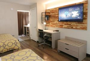 a bedroom with a television and a bed at Baymont by Wyndham Gatlinburg On The River in Gatlinburg