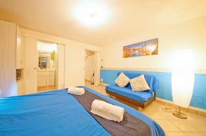 a bedroom with a blue bed and a couch at DolceVita Apartments N. 481 Biennale in Venice