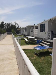 un parque de caravanas con mesas de picnic y una valla en Campeggio Praia Mare, en Campofelice di Roccella