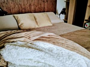 a bed with a blanket and pillows on it at appartment & rooms SecondoPiano in Cividale del Friuli