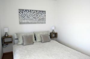 a bedroom with a white bed with two lamps at Apartmani Alta in Krk