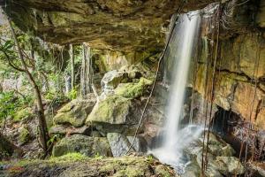 a waterfall on the side of a rocky cliff at Ecopradera Lodge in San José del Guaviare