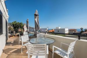 balkon z krzesłami i stołem na dachu w obiekcie Candelaria Relax w mieście Candelaria