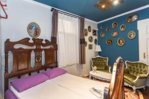 ein Schlafzimmer mit einem Bett und einem Stuhl und Platten an der Wand in der Unterkunft Social Guest House in Sofia