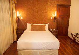 1 dormitorio con 1 cama blanca grande en una habitación en Hotel Carvallo, en Cuenca