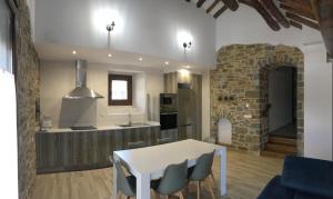 a kitchen with a white table and chairs in a room at Apartamentos Bajo Peña Apartamentos Sanlorien in El Pueyo de Araguás