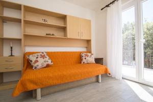 um banco laranja num quarto com uma janela em Seafront Apartment Dana em Vela Luka