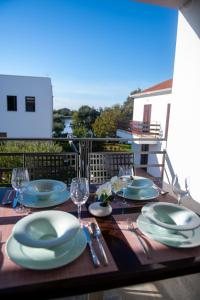 een tafel met borden en wijnglazen op een balkon bij Bella Apartments Zaton in Zaton