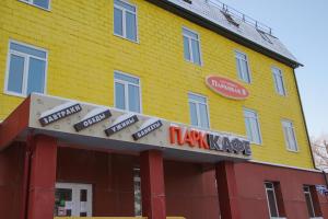un edificio amarillo con letreros en el costado en Parkovaya 9, en Severodvinsk