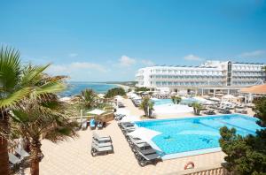 
a beach scene with a large swimming pool at Insotel Hotel Formentera Playa in Playa Migjorn
