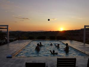 a group of people in a swimming pool at sunset at Tenuta San Marcello in San Marcello