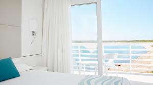 a bedroom with a bed and a view of the ocean at Insotel Hotel Formentera Playa in Playa Migjorn