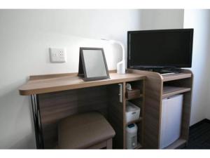 a computer desk with a monitor and a computer monitor at R&B Hotel Shin Osaka Kitaguchi - Vacation STAY 15208v in Osaka +20 photos