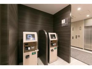 uma máquina de multibanco num edifício com uma parede preta em R&B Hotel Shin Osaka Kitaguchi - Vacation STAY 15208v em Osaka