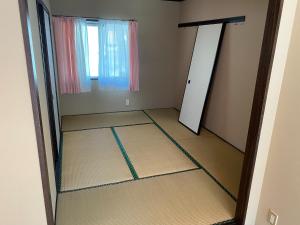 Grand Heights - Vacation STAY 17555v في Amakusa: غرفة فارغة مع مرآة وباب