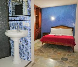 a bathroom with a sink and a bed in a room at HOTEL YORYTANIA BOUTIQUE in Pitalito