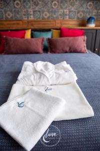 two white towels sitting on top of a bed at Luna Homes in Sibiu