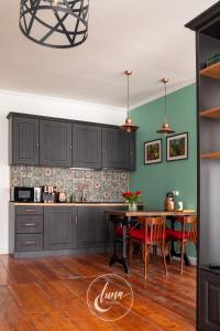 a kitchen with black cabinets and a table with red chairs at Luna Homes in Sibiu