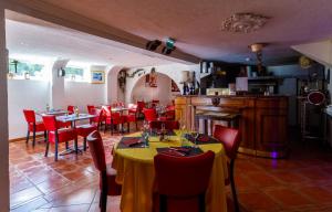 a restaurant with tables and red chairs in a room at Hôtel Restaurant Kuentz in Wittersdorf