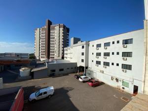 a parking lot with cars parked in front of a building at Dallas Hotel in Palotina +23 photos