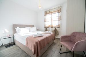 sypialnia z łóżkiem, krzesłem i oknem w obiekcie Bella Apartments Zaton w mieście Zaton
