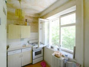 a kitchen with a stove and a window in it at Cozy room nearly the United Exhibition Center on the metro station Levoberejnaya. in Kyiv