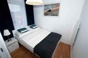 um quarto com uma cama com uma fotografia na parede em Apartament IKAR ul. Grunwaldzka blisko morza em Pobierowo