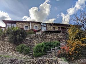 una casa en la parte superior de una pared de piedra en Olmares Apartamento Picos de Europa, en Pesaguero-La Parte