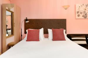 a bedroom with a large white bed with red pillows at Manina Superior Apartment in Thessaloniki