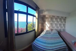 a bedroom with a bed with a view of the ocean at Hospedagem Praia da Costa in Vila Velha