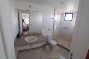 a bathroom with a sink and a toilet and a mirror at Hospedagem Praia da Costa in Vila Velha +37 photos