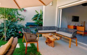 a patio with chairs and a table and an umbrella at JADE DUPLEX in Nosy Be